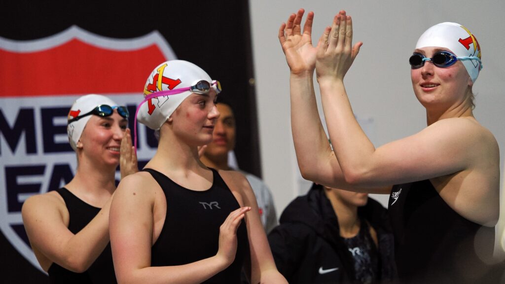 VMI swimmers stand and applaud.