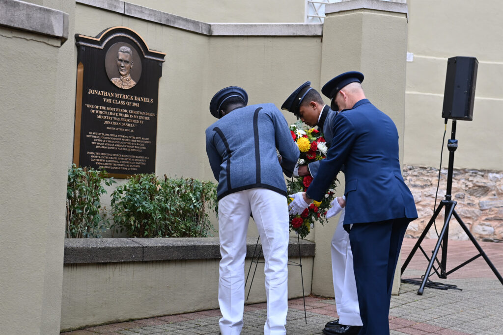 Cadets and the Commandant place a wreath in front of a plaque honoring Jonathan Daniels.
