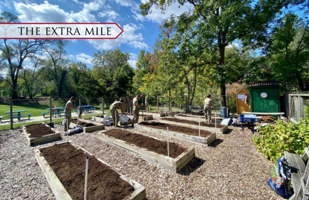 Student fill raised beds with dirt during a community service event.