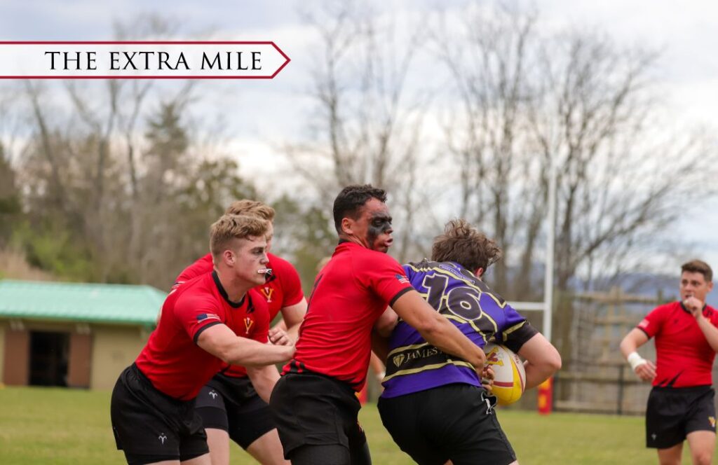 A group of athletes playing rugby on the field.