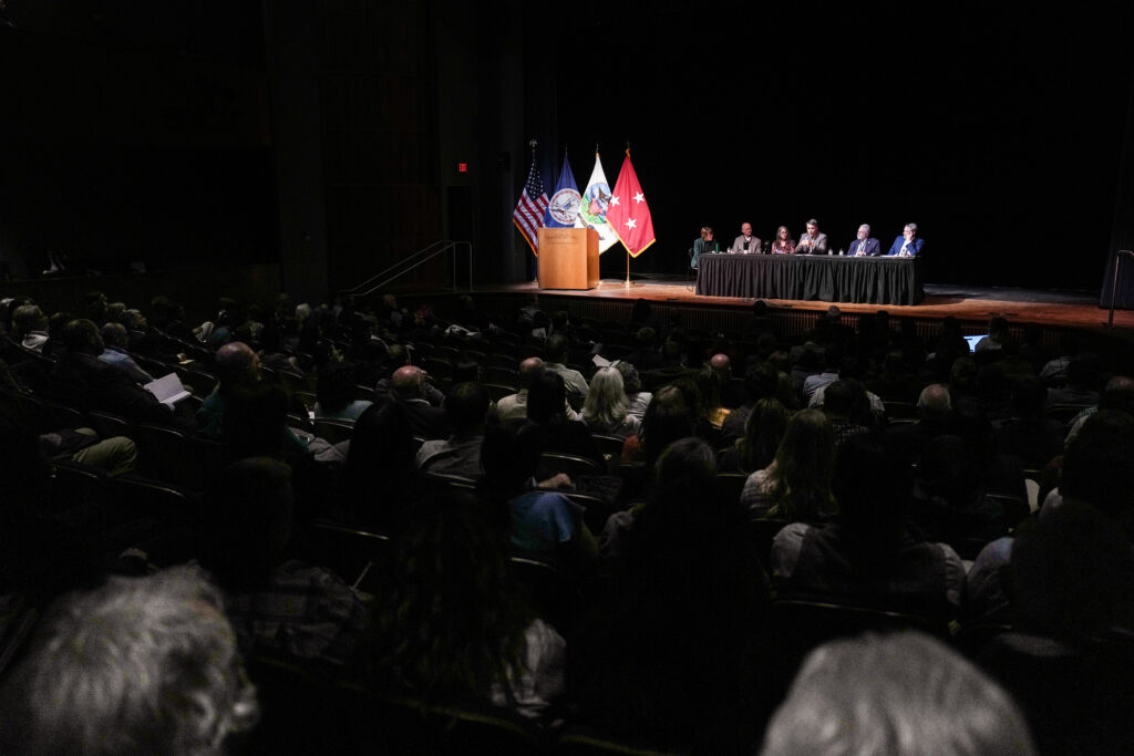 A moderator and panel take the stage in Gillis Theater.