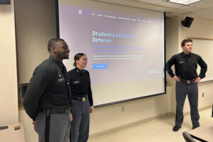 Cadets stand in front of a screen.