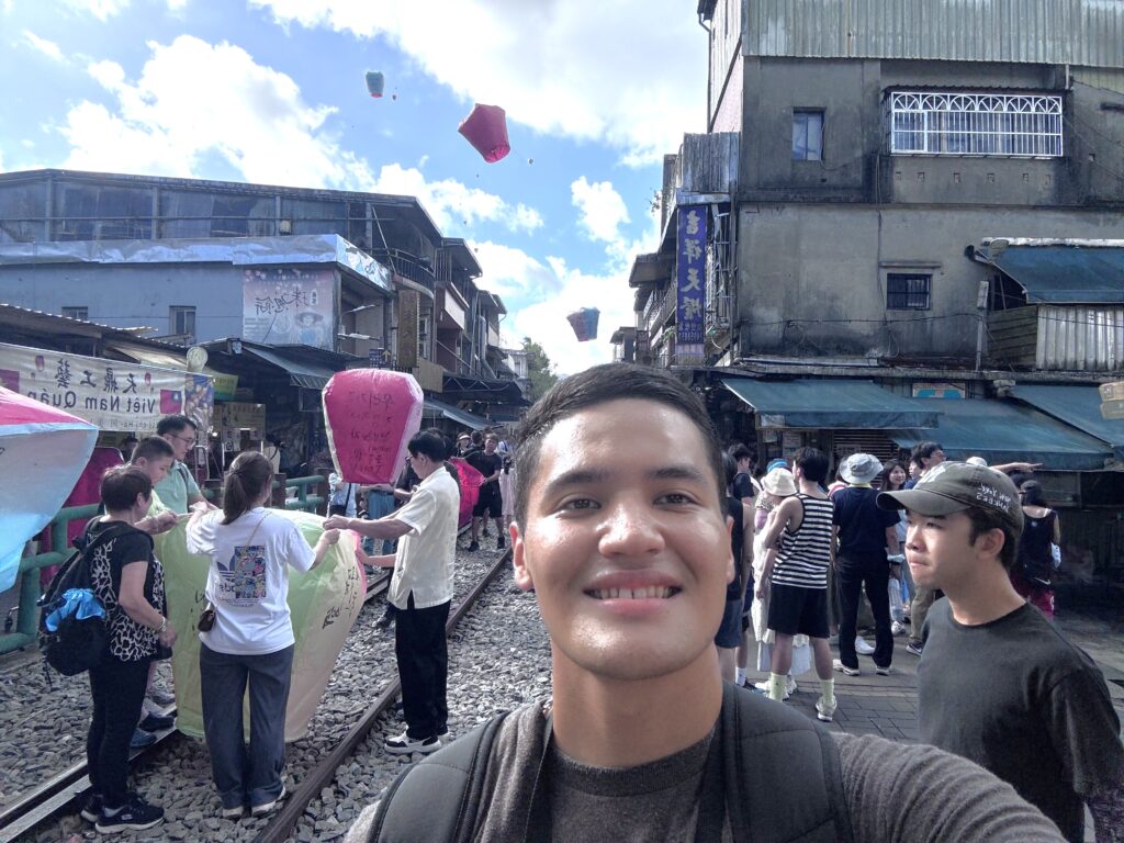 Cadet takes a selfie as lanterns are released behind him.