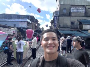Cadet takes a selfie as lanterns are released behind him.