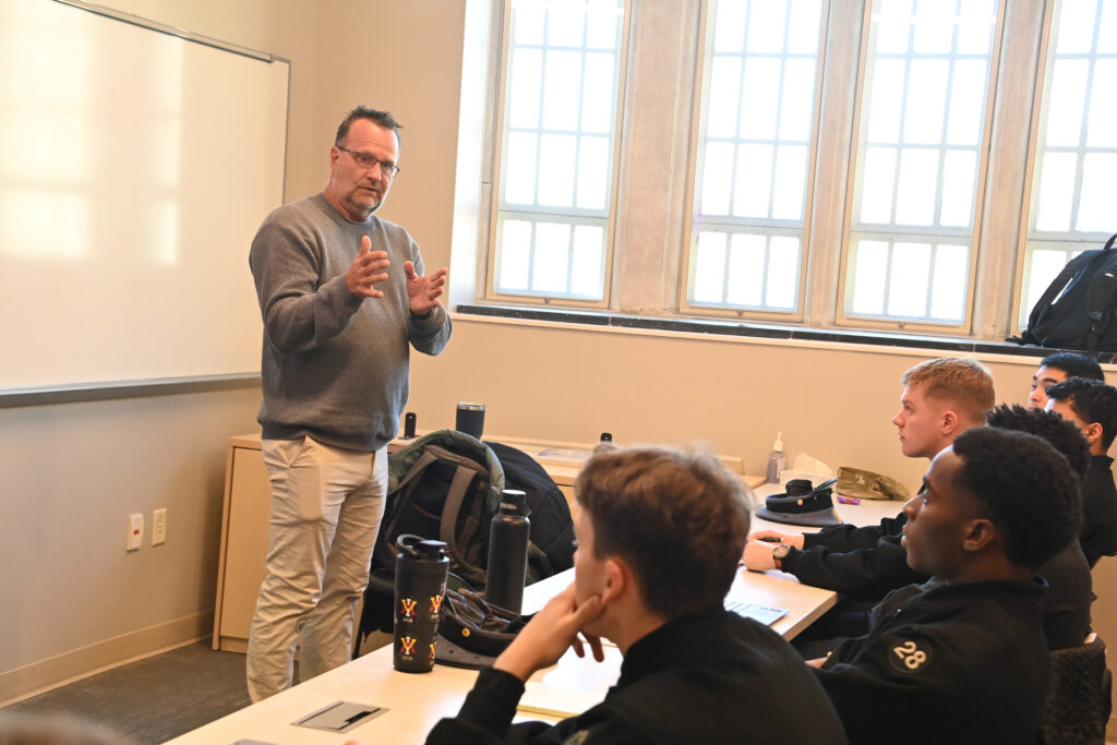 Scott Mann stands in a classroom speaking to VMI cadets.