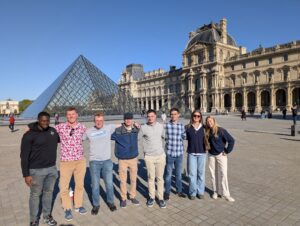 Cadets pose for a photo in front of the Louvre.
