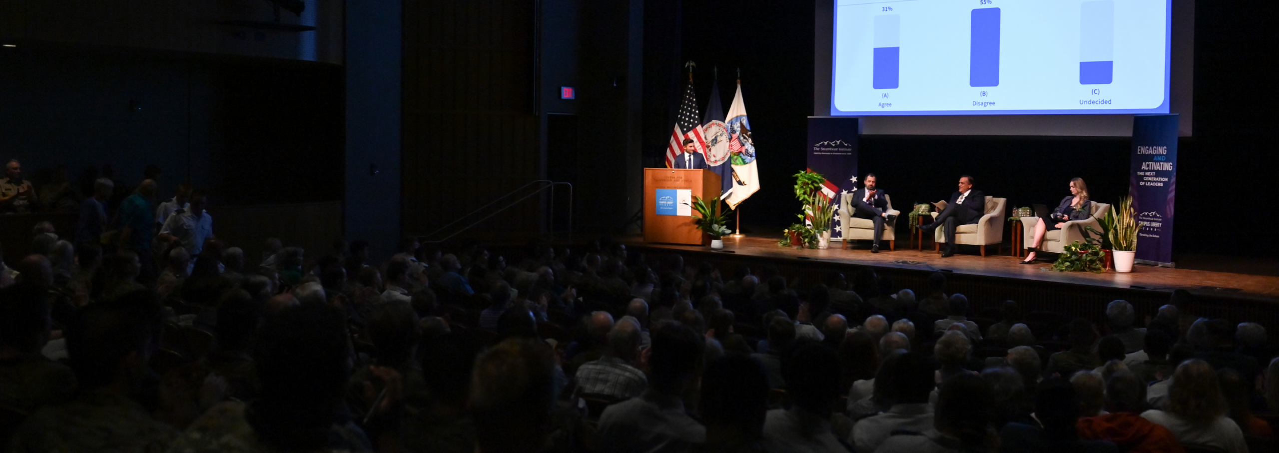 Prominent guest speakers address debate attendees in Gillis Theater.
