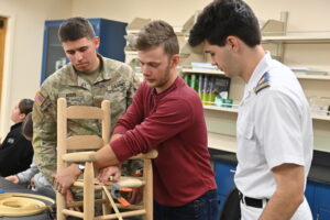 Seven cadets in a general botany class explored practical plant uses by learning the art of chair caning. Led by Col. Anne Alerding, the hands-on session featured local artisan Andrew Hart, who taught students to weave chair seats using flat reed from rattan palms.