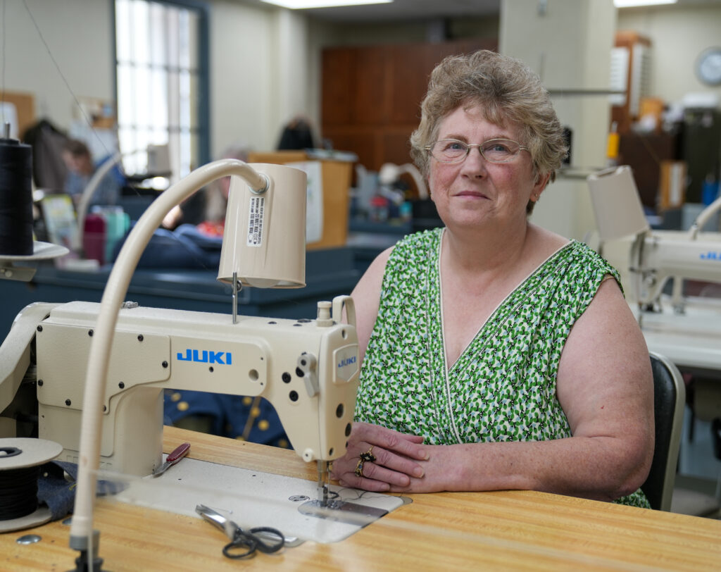VMI tailor shop manager Cindy Hartbarger in front of her sewing machine.