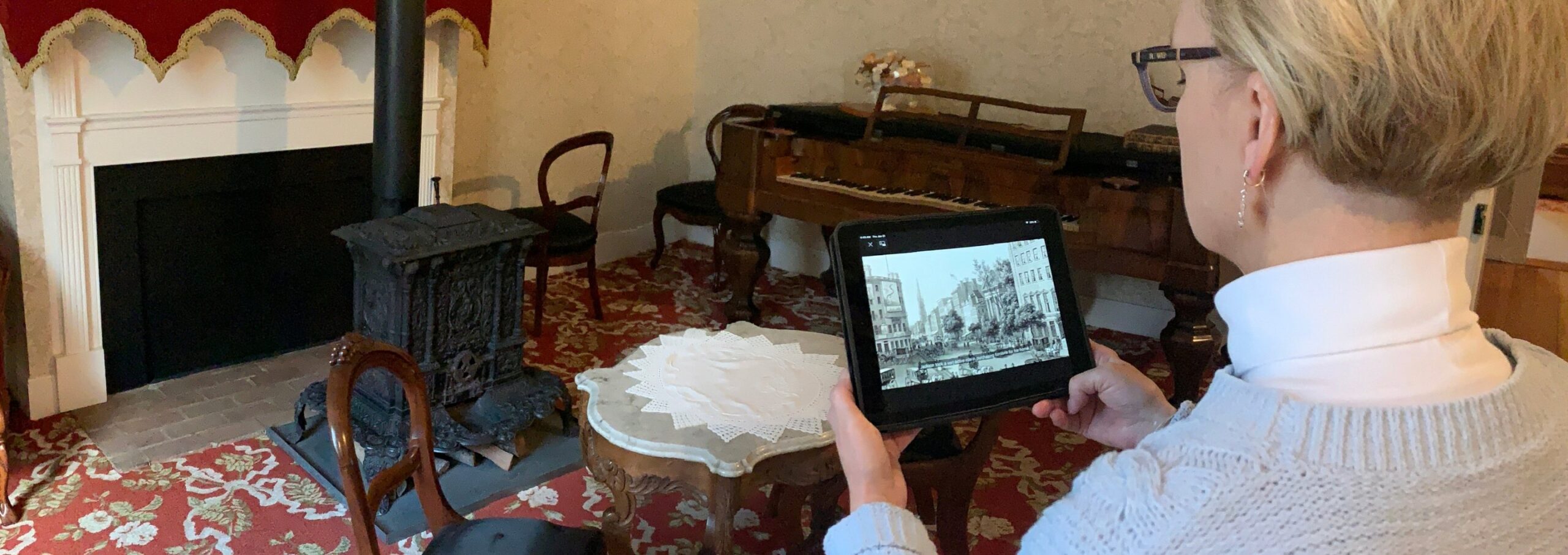 A museum visitor uses a tablet to watch a self-guided tour video.