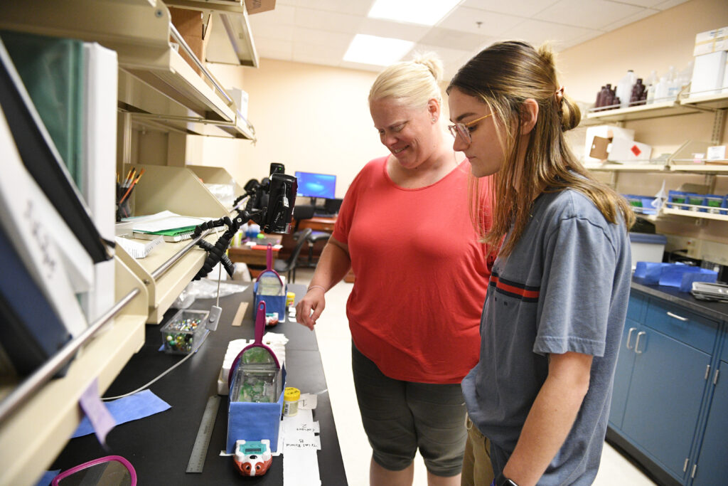 Ellie Pickford '24 in front of research equipment.