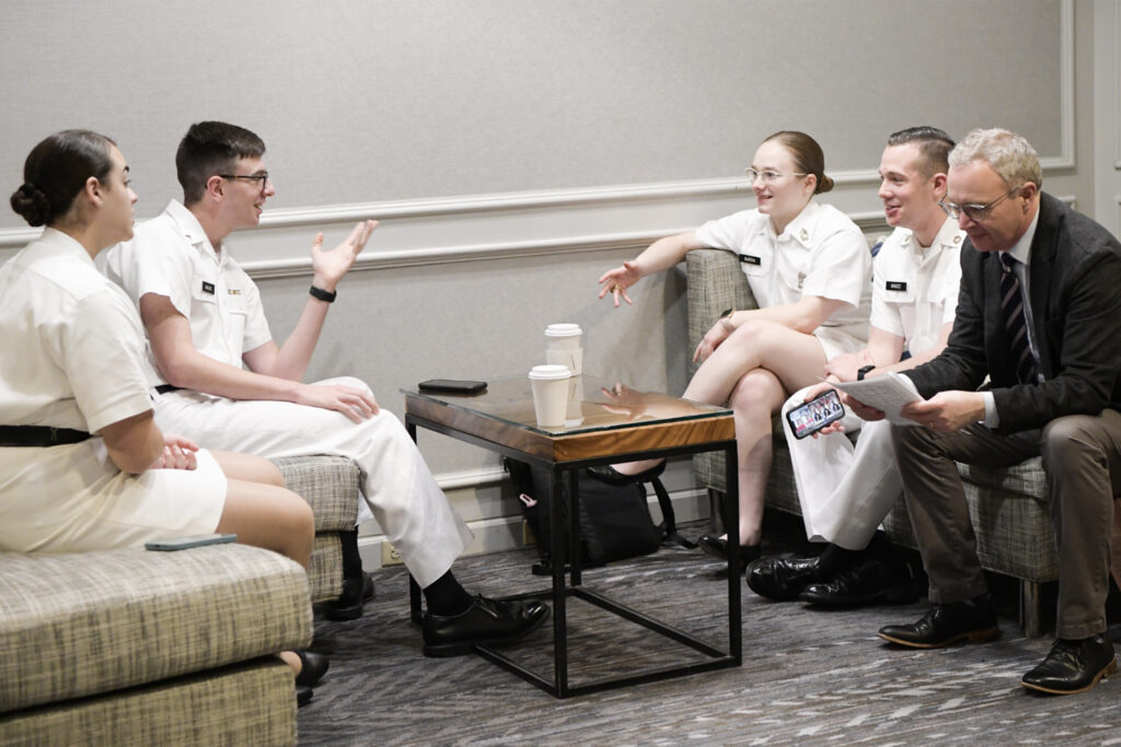 VMI ethics team members Gabriele Woodward '24, and Riley Malone '25, Harris Burton '23, and Riley Shultz '24 discuss strategy with their coach, Dr. Duncan Richter.