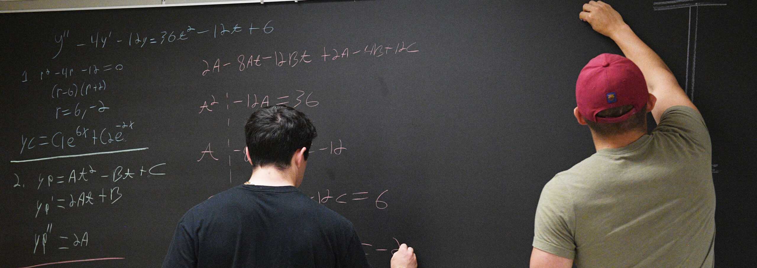 Two students work on a math equation during summer session classes.