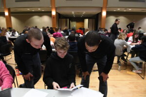 Cadets help a middle schooler with math.