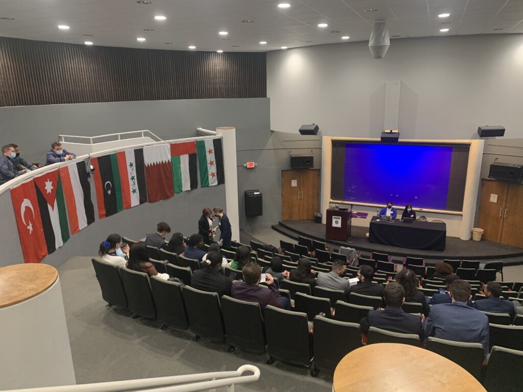 Riley Shultz ’24, Christian Cole ’24, and Parker Rice ’24 confer on debate strategy in the balcony overlooking the assembly at the Model Arab League.
