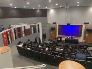 Riley Shultz ’24, Christian Cole ’24, and Parker Rice ’24 confer on debate strategy in the balcony overlooking the assembly at the Model Arab League.