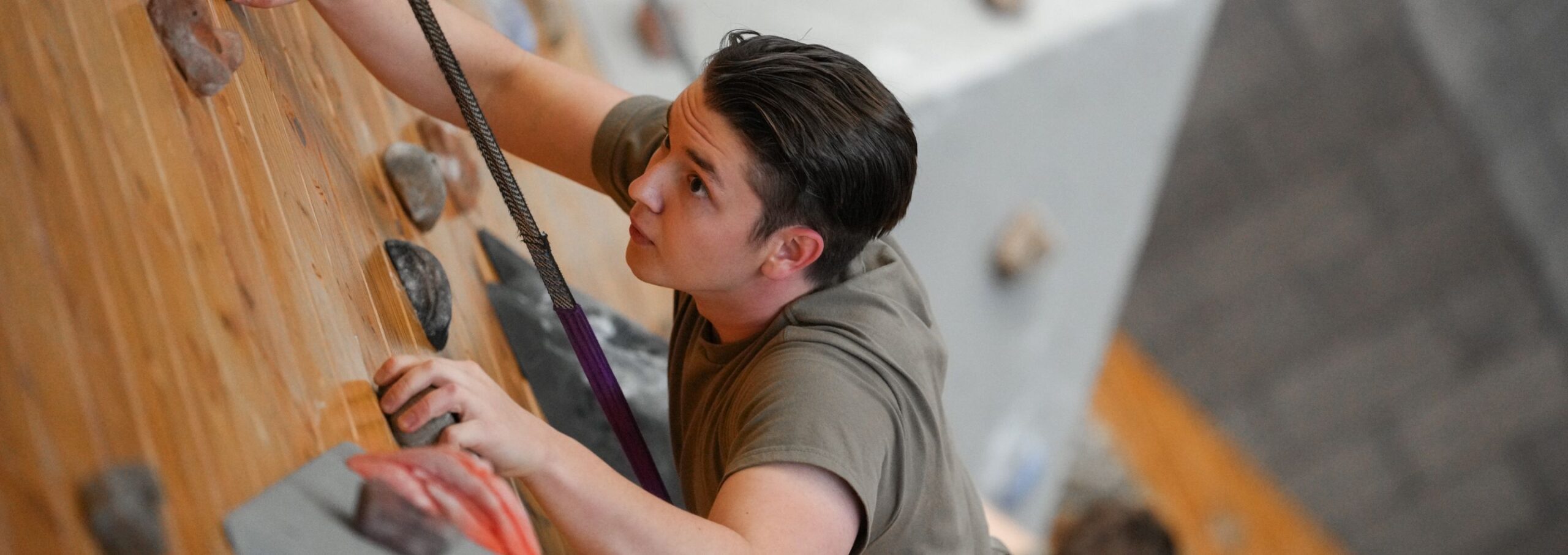 A cadet scales the rock wall.