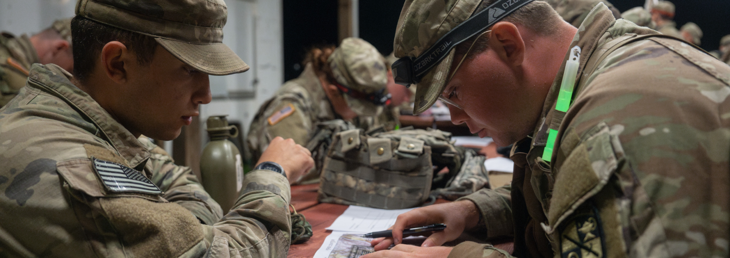 Army ROTC cadets look over field guides.
