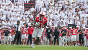 A VMI football players runs on the field at Foster Stadium with the Corps of Cadets in the stands.