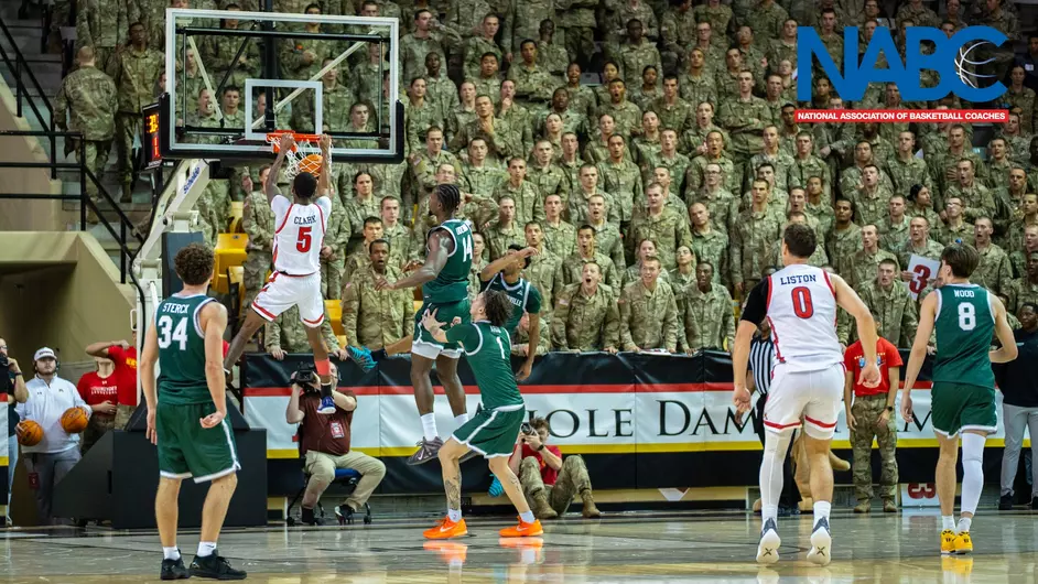 VMI basketball player dunks in Cameron Hall as the Corps watches on.