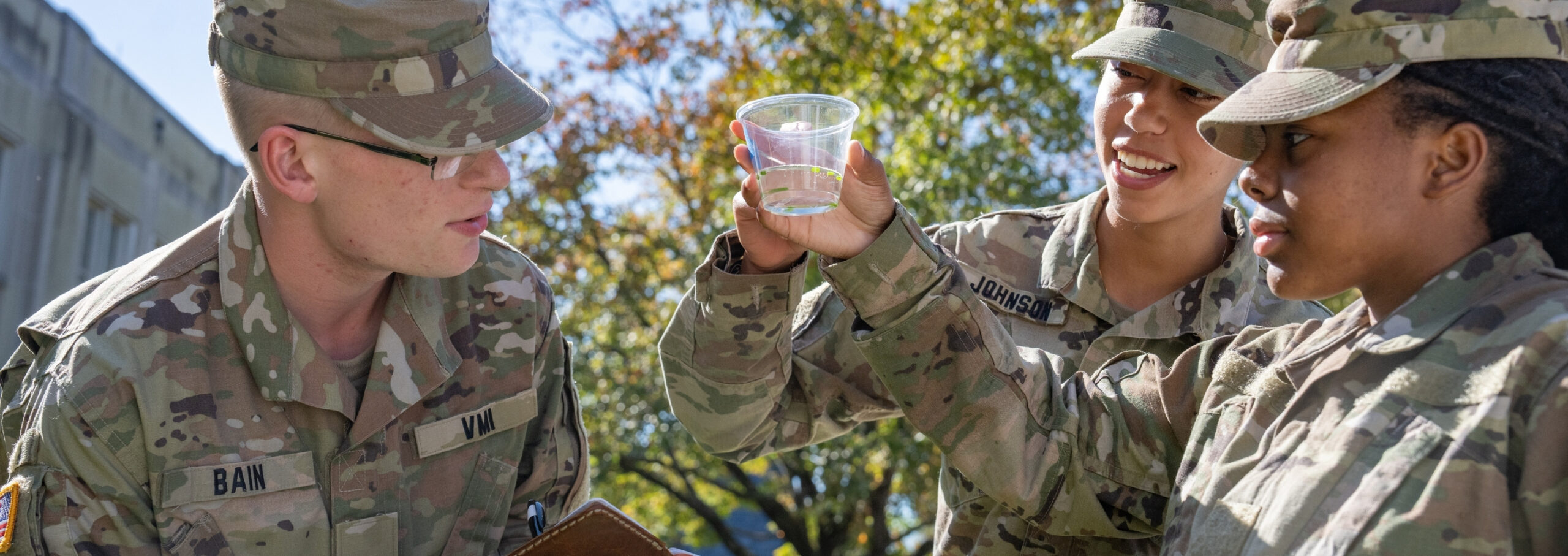 Biology students (cadets at VMI) study a sample outdoors.