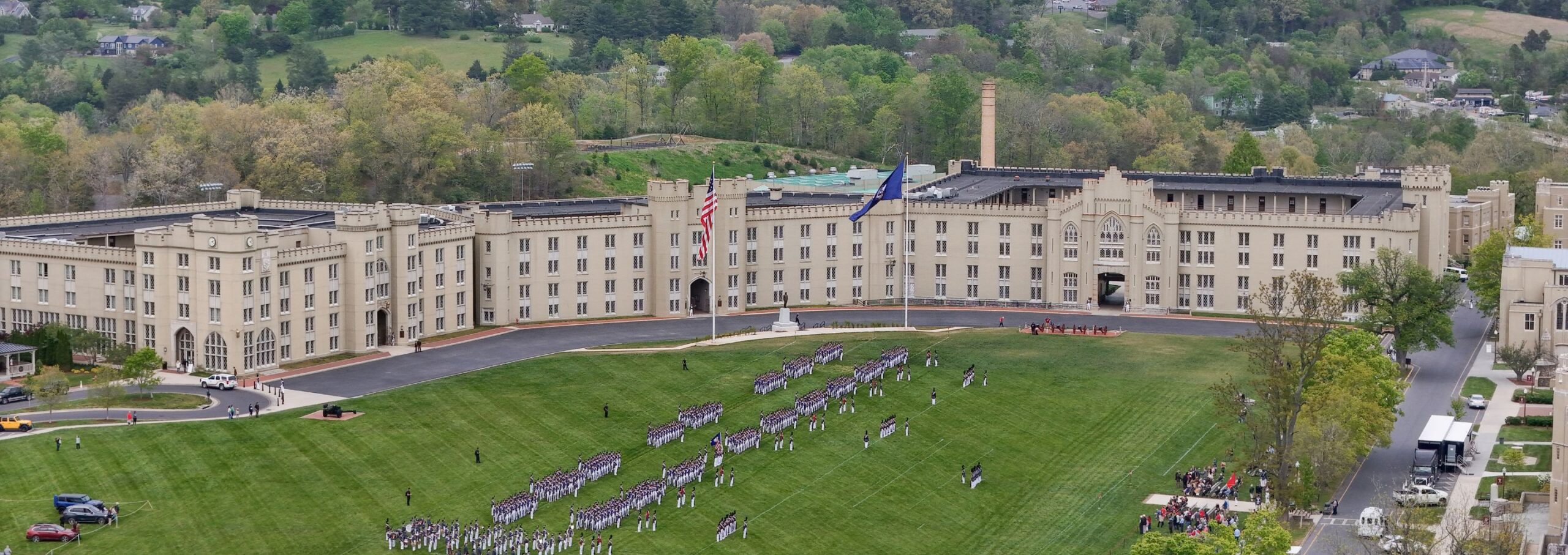 Aerial shot of barracks while cadets take the field for parade.
