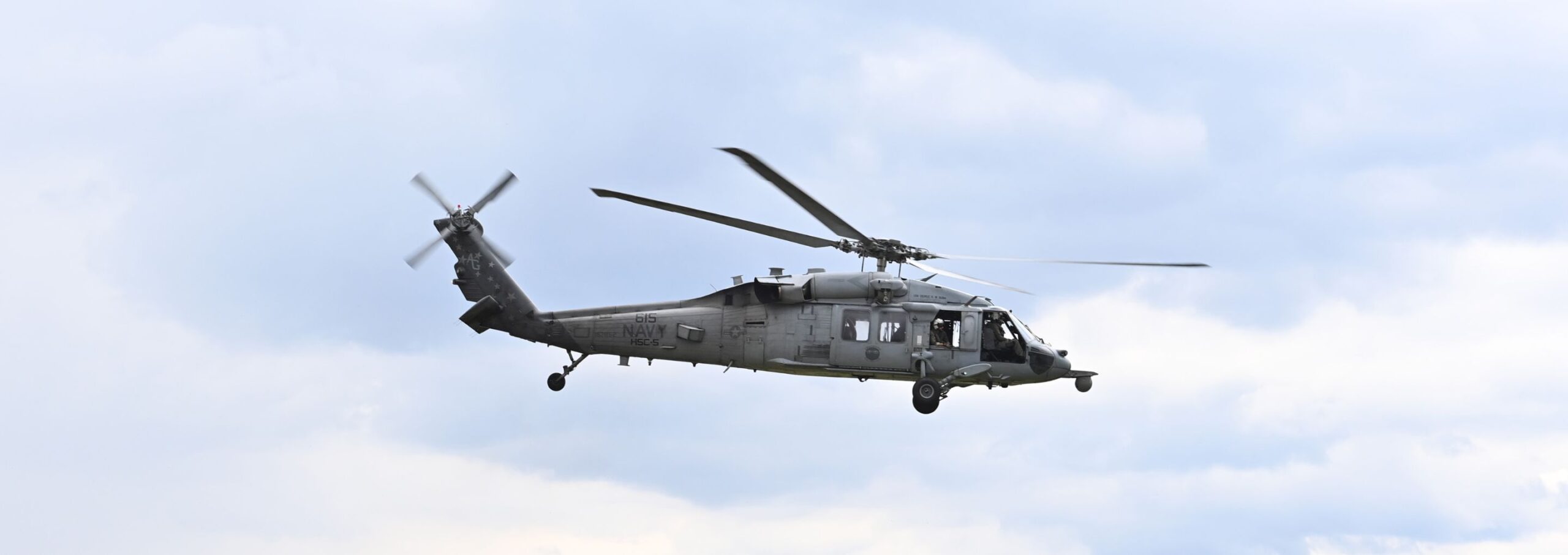 A Navy helicopter flies above barracks.