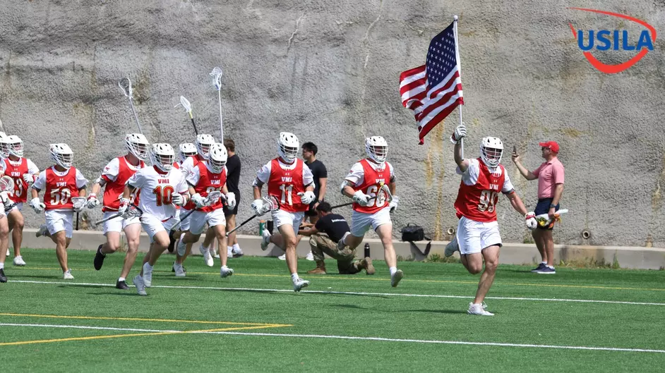 Lacrosse team members run onto the field.