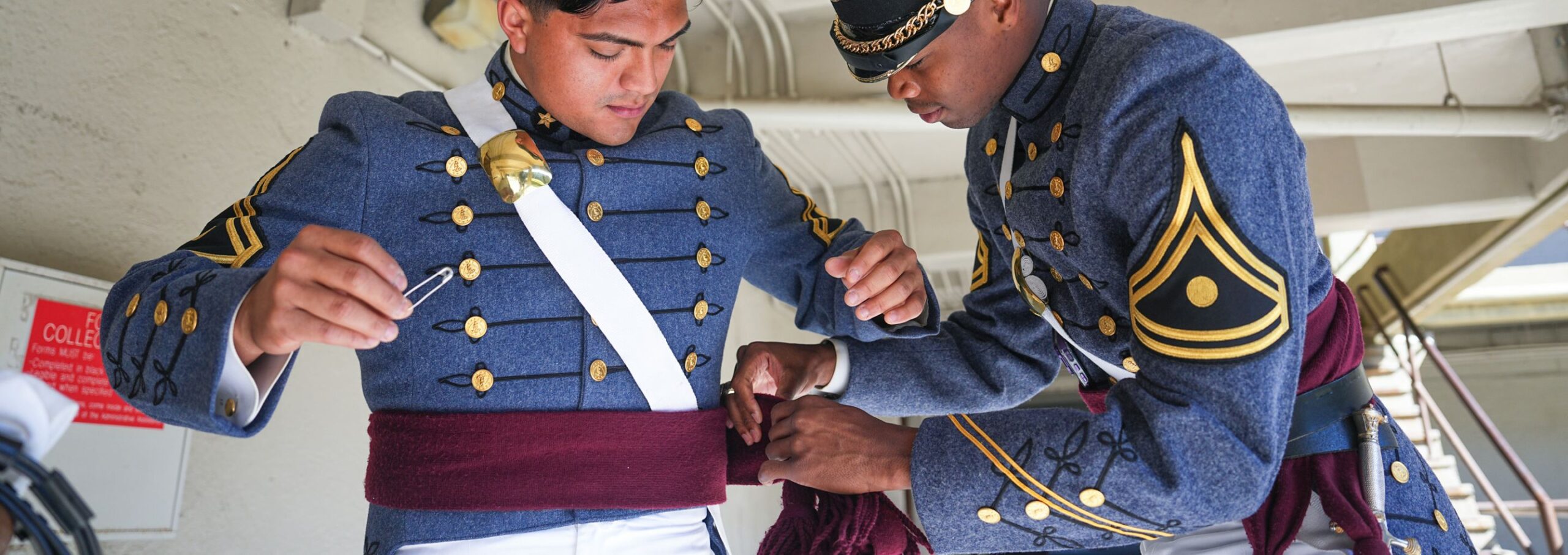 Cadets get dressed in their uniforms for parade.