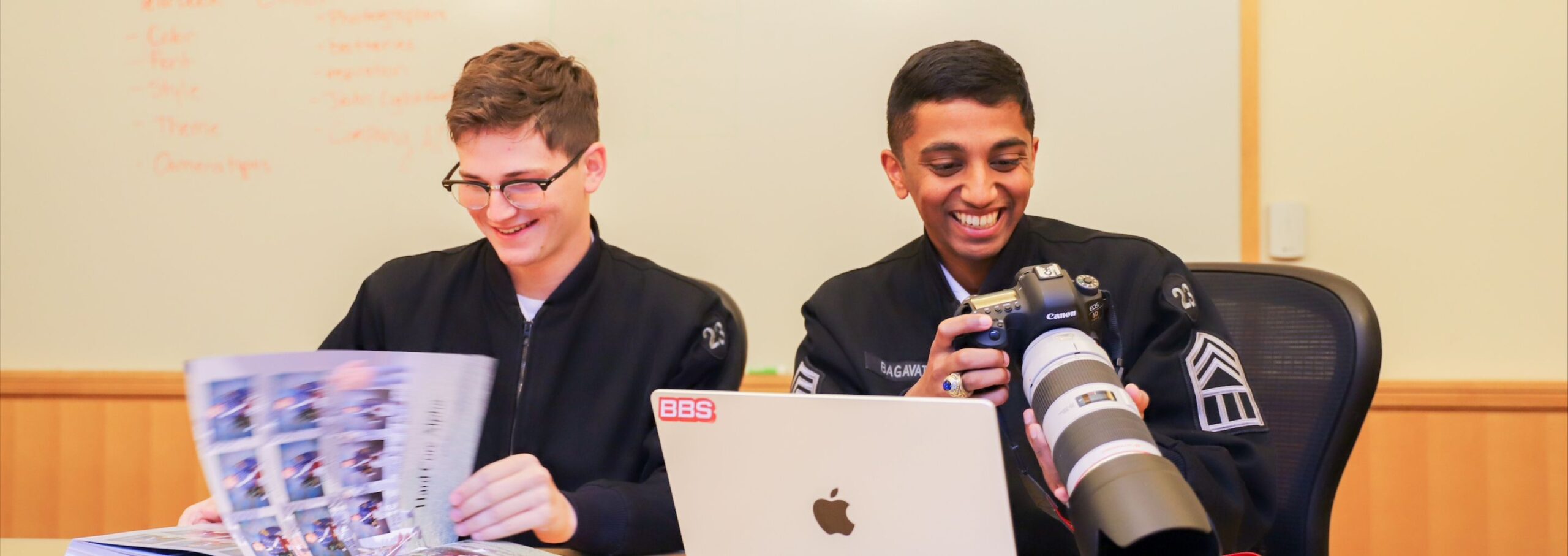 Two cadets sort through photos for the yearbook.